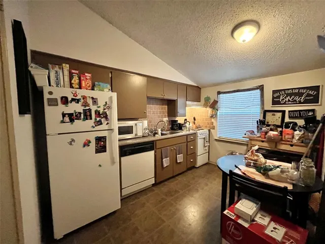 a kitchen with stainless steel appliances kitchen island granite countertop a stove and a refrigerator