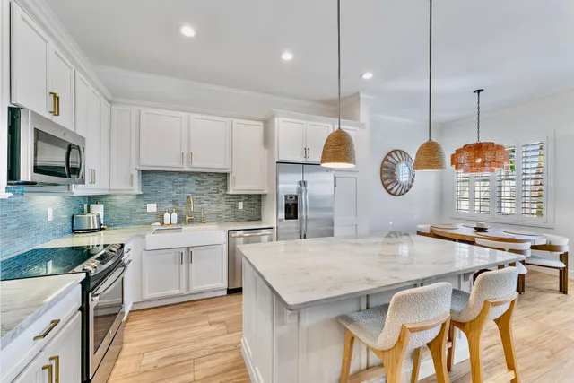 a kitchen with granite countertop white cabinets sink and stainless steel appliances