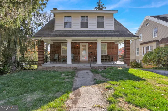 a view of a brick house with a large windows and a yard