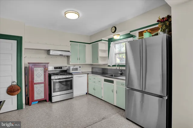 a kitchen with stainless steel appliances granite countertop a refrigerator a sink and a stove