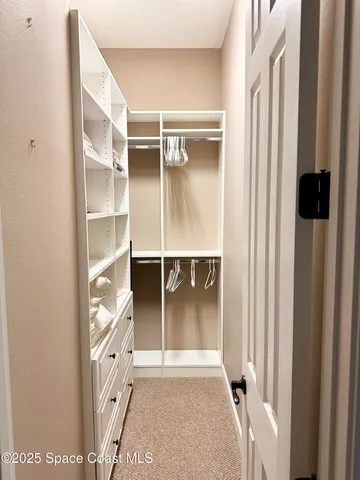 a view of walk in closet with empty racks