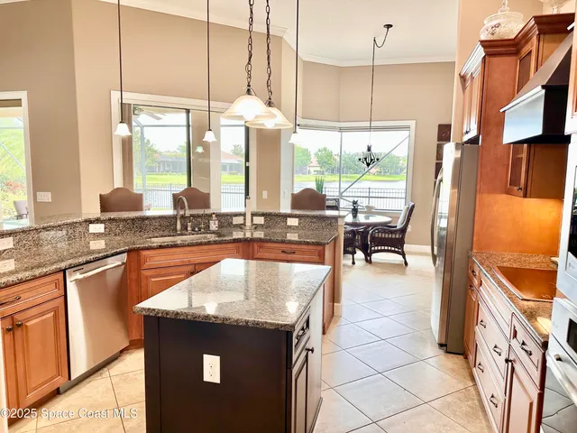 a kitchen with granite countertop a stove a sink and a refrigerator