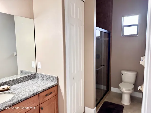 a bathroom with a granite countertop toilet and a sink