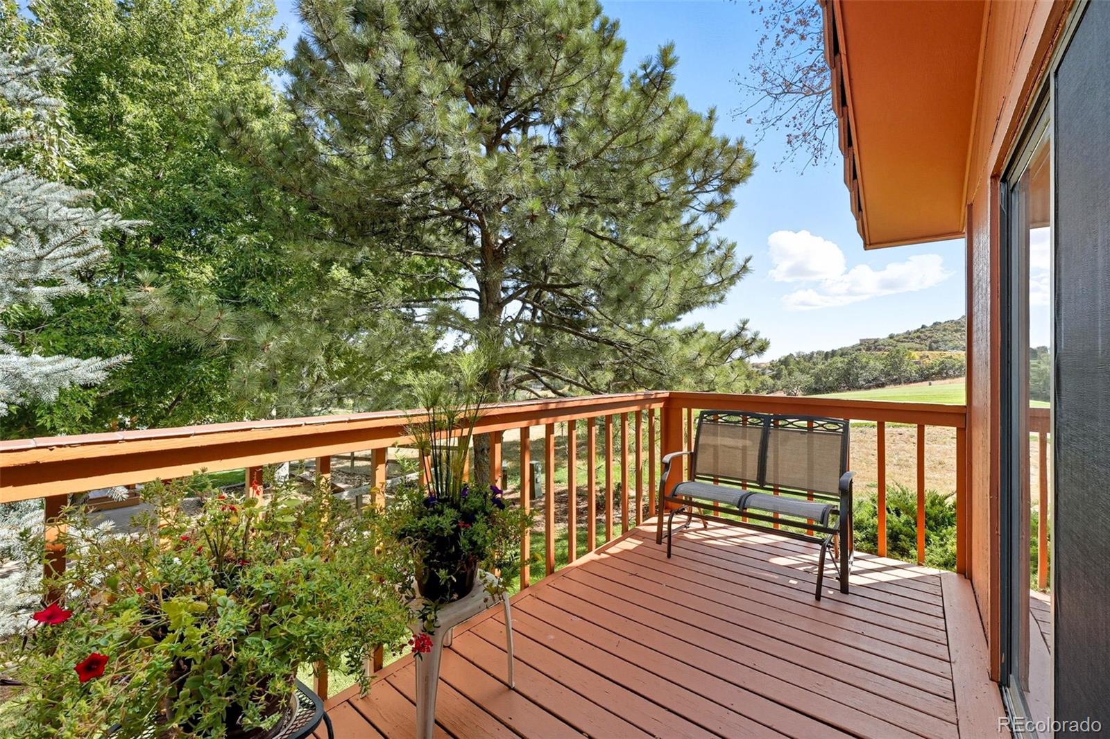 16066 Ridge Tee Drive Morrison, CO 80465 - Photo 11 of 41 a balcony with wooden floor and fence