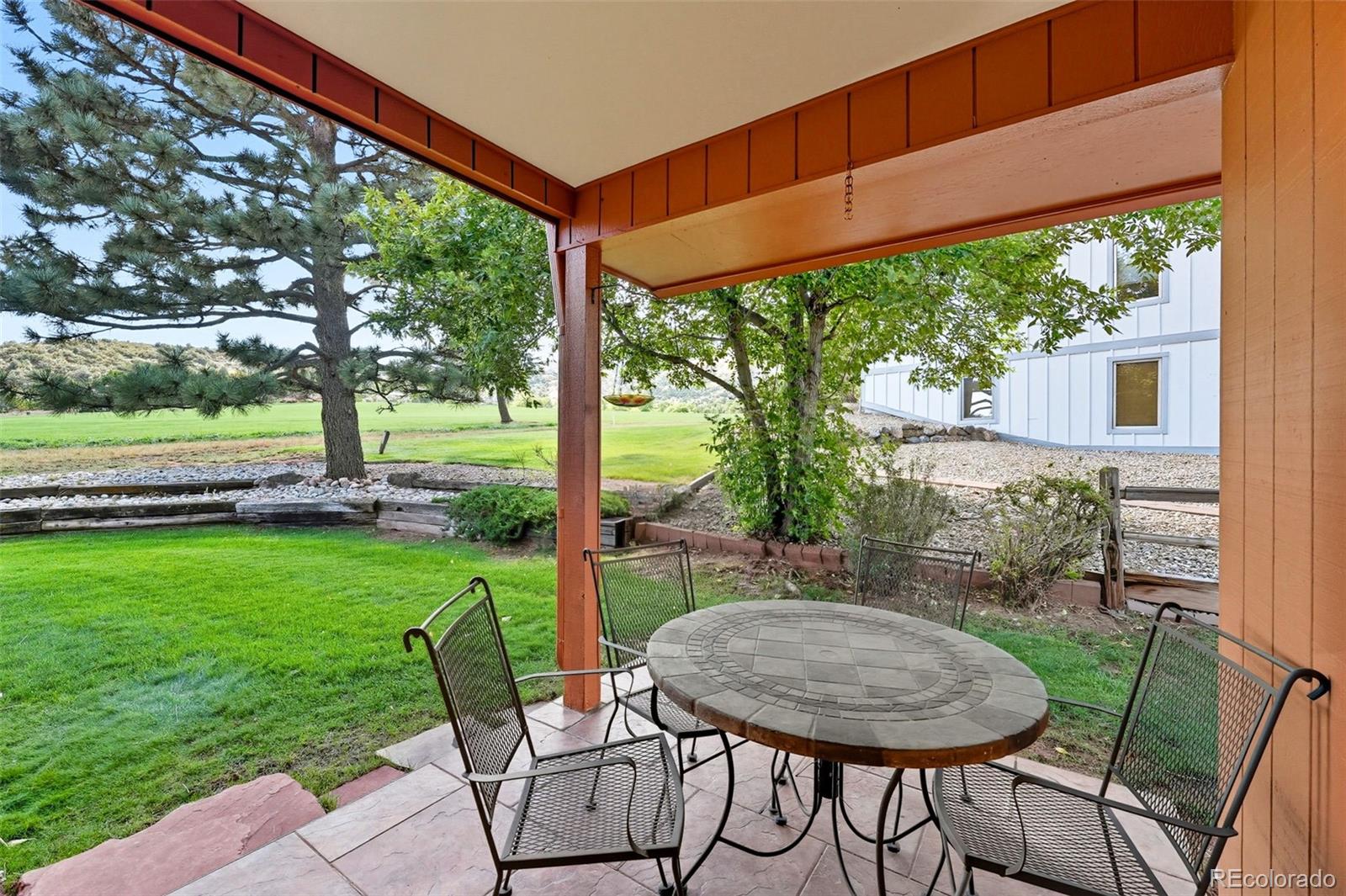16066 Ridge Tee Drive Morrison, CO 80465 - Photo 12 of 41 a view of a patio with a table chairs and a backyard