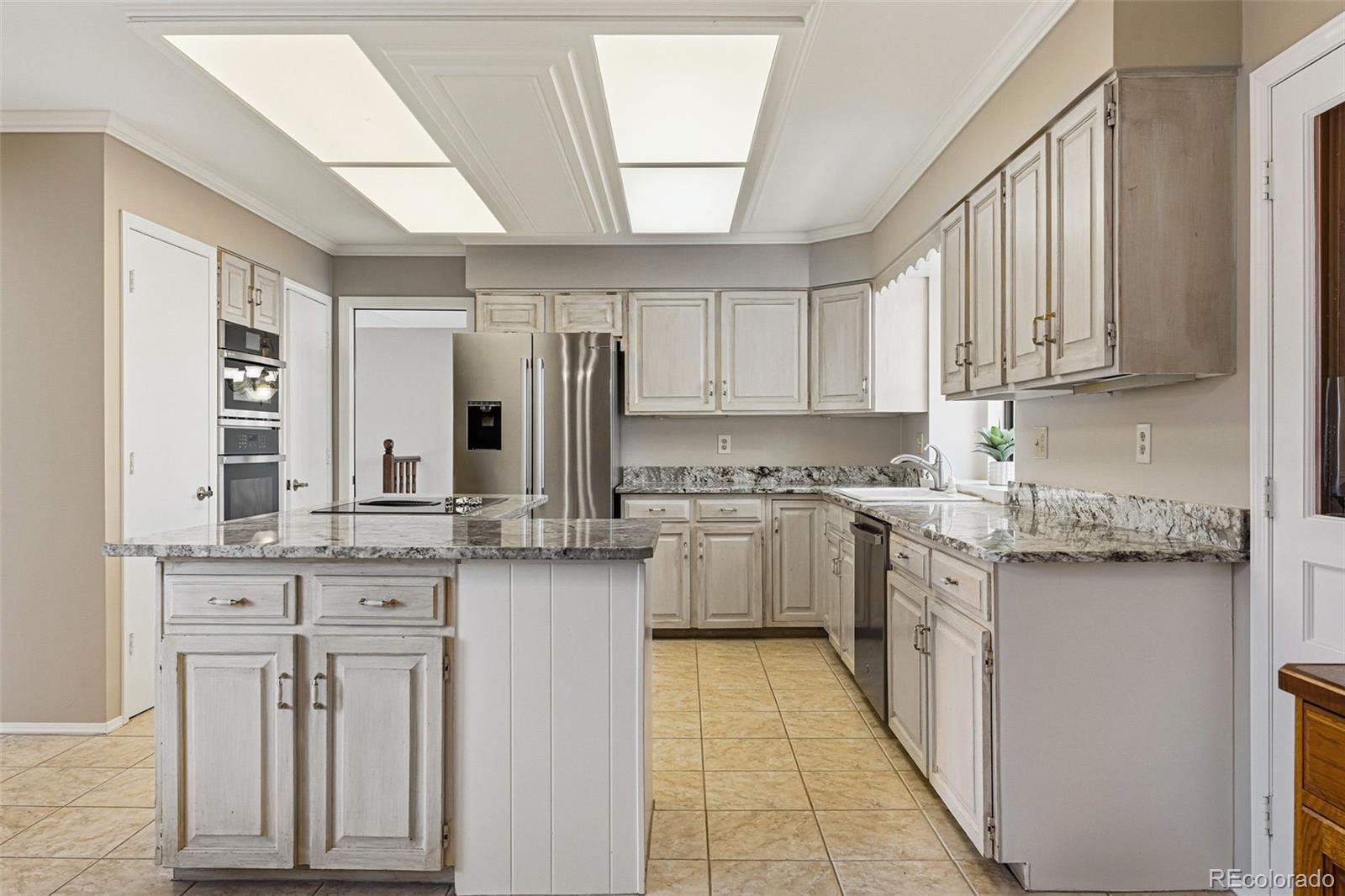 16066 Ridge Tee Drive Morrison, CO 80465 - Photo 20 of 41 a kitchen with stainless steel appliances granite countertop a stove a sink and a refrigerator