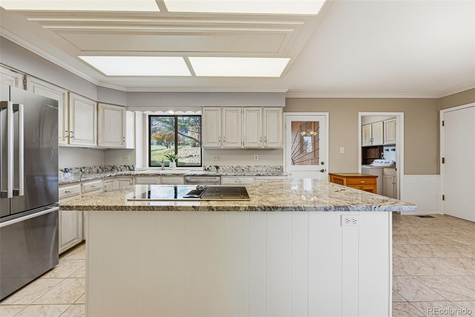 16066 Ridge Tee Drive Morrison, CO 80465 - Photo 22 of 41 a kitchen with granite countertop a sink window and cabinets
