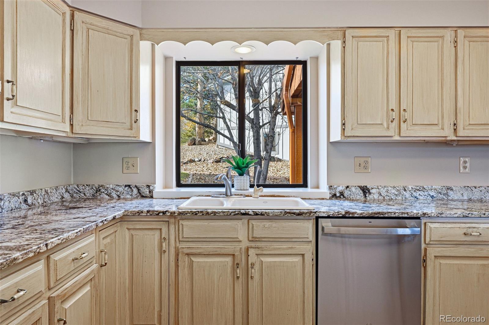 16066 Ridge Tee Drive Morrison, CO 80465 - Photo 23 of 41 a kitchen with granite countertop a sink and a window