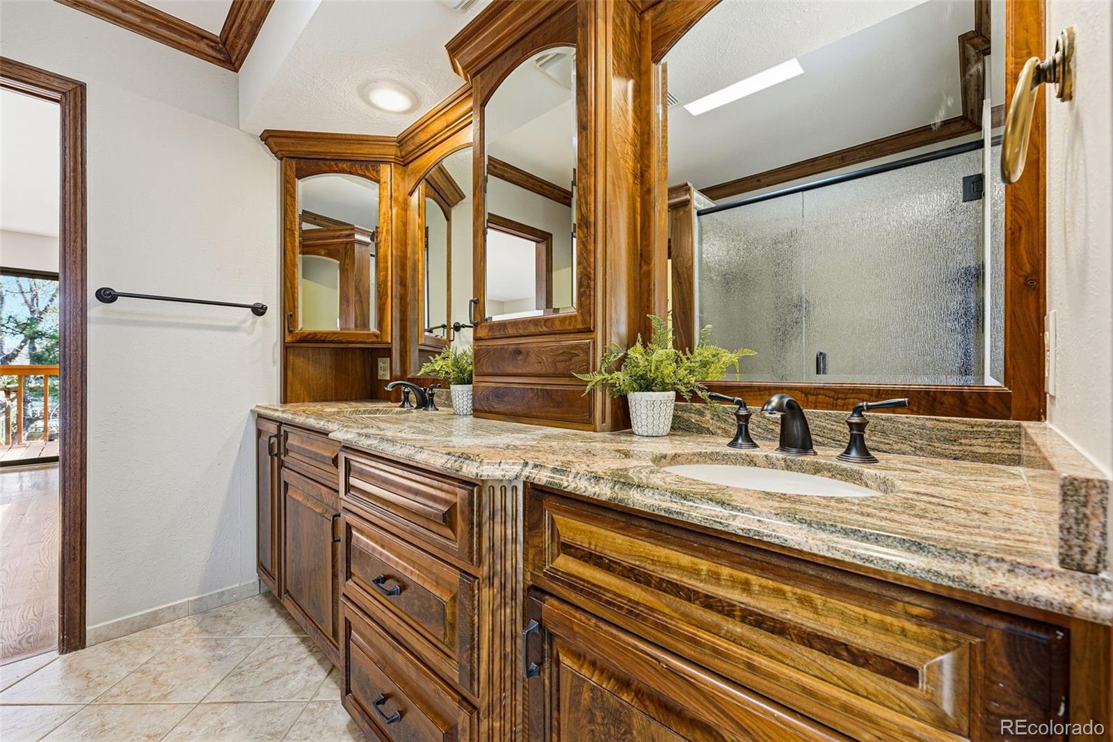 16066 Ridge Tee Drive Morrison, CO 80465 - Photo 29 of 41 a bathroom with a granite countertop sink and a mirror