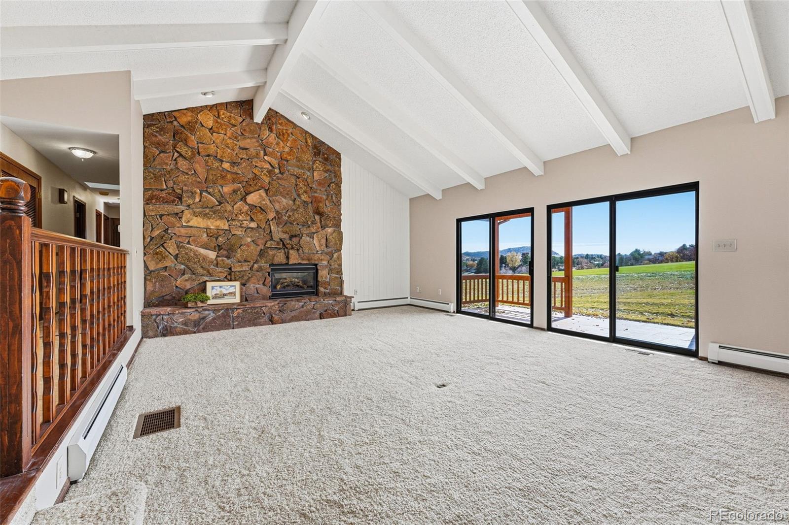 16066 Ridge Tee Drive Morrison, CO 80465 - Photo 4 of 41 an empty room with fireplace and windows