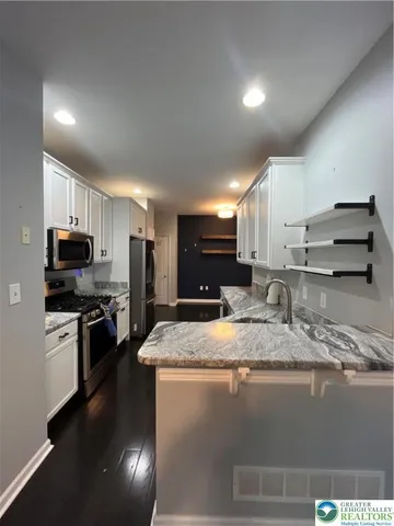a kitchen with stainless steel appliances granite countertop a sink dishwasher stove and refrigerator