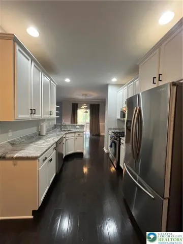 a kitchen with stainless steel appliances granite countertop a refrigerator a sink and a stove