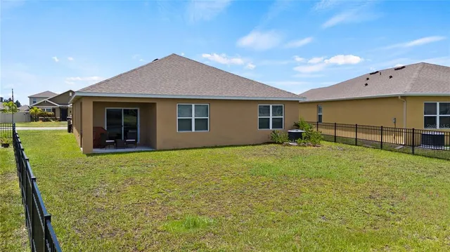 a backyard of a house with yard table and chairs