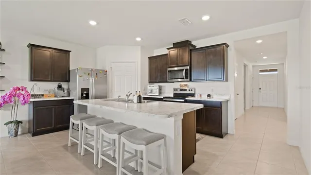 a open kitchen with stainless steel appliances granite countertop a sink stove and refrigerator