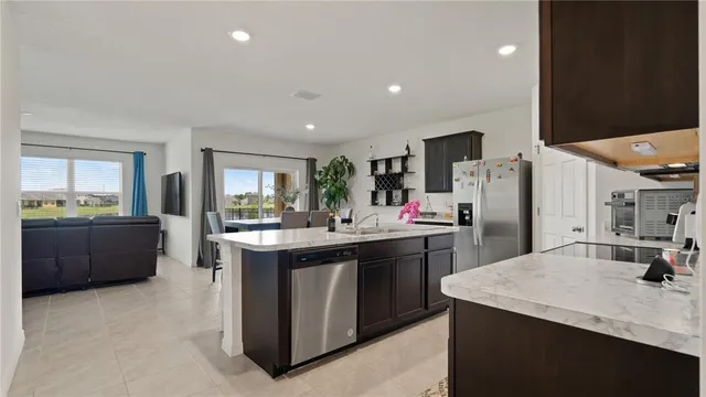 a kitchen with stainless steel appliances kitchen island granite countertop a sink and cabinets