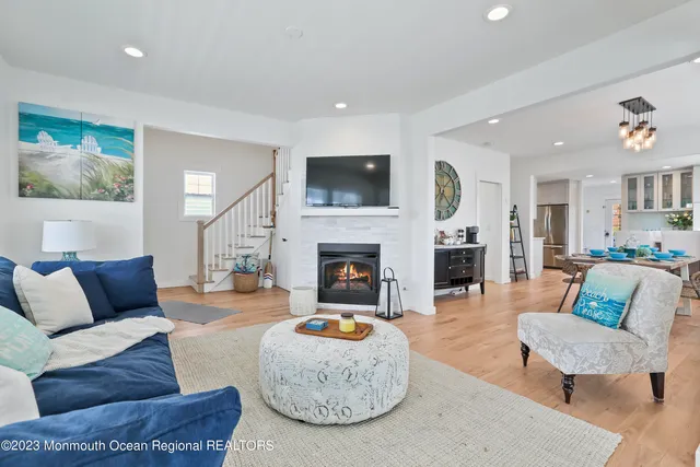 a living room with furniture a flat screen tv and a fireplace
