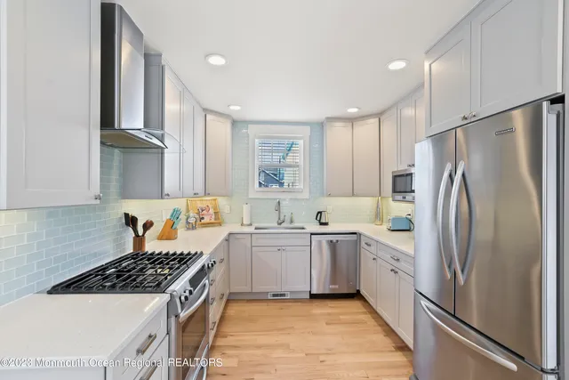 a kitchen with white cabinets and appliances