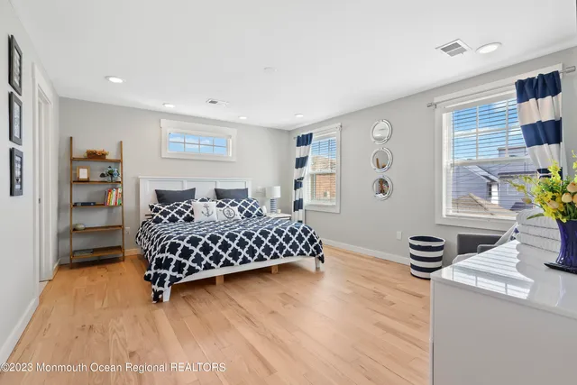 a bedroom with a bed and a table in it with wooden floor