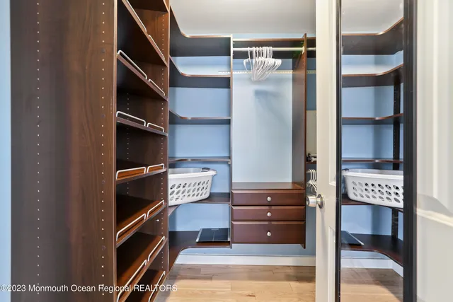 a view of walk in closet with clothes and shoes