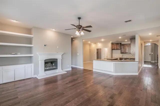 a large kitchen with hardwood floor a sink and stainless steel appliances