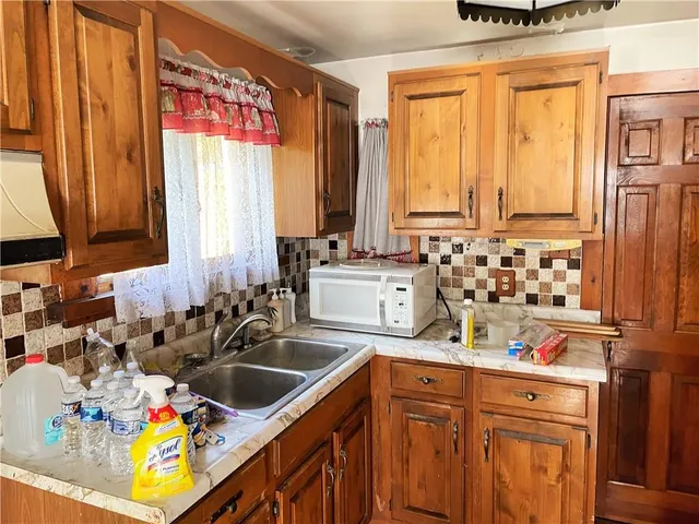 a kitchen with sink a window and chairs