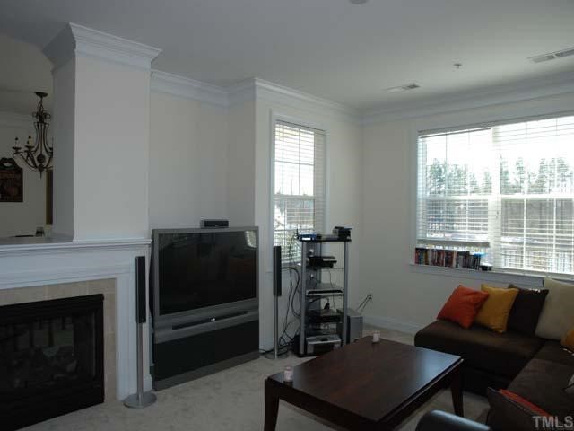 10511 Rosegate Court, Unit 6 Raleigh, NC 27617 - Photo 3 of 11 a living room with furniture a flat screen tv and a fireplace