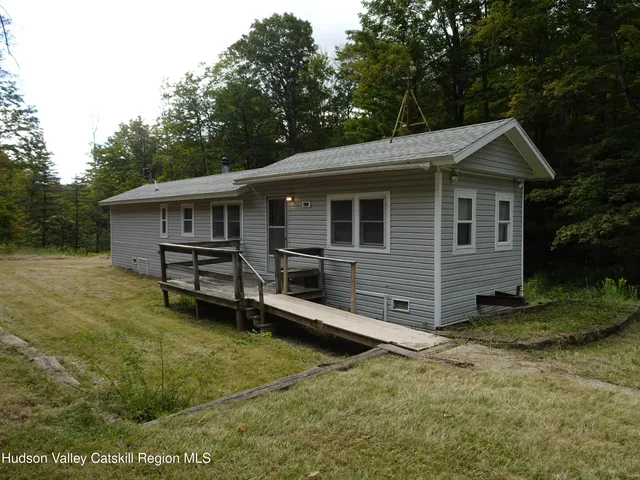 a view of a house with a yard and wooden fence