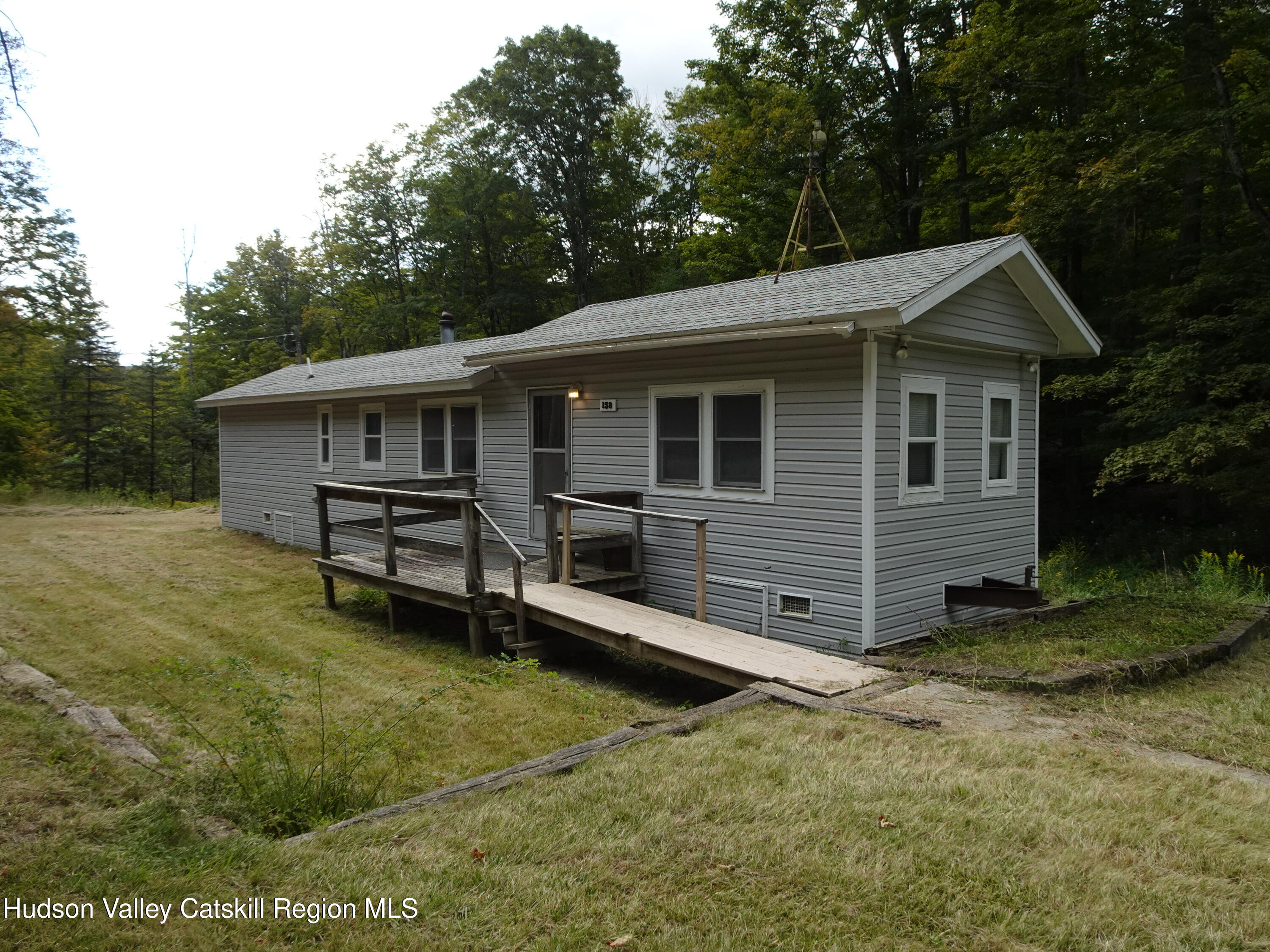 a view of a house with a yard and wooden fence