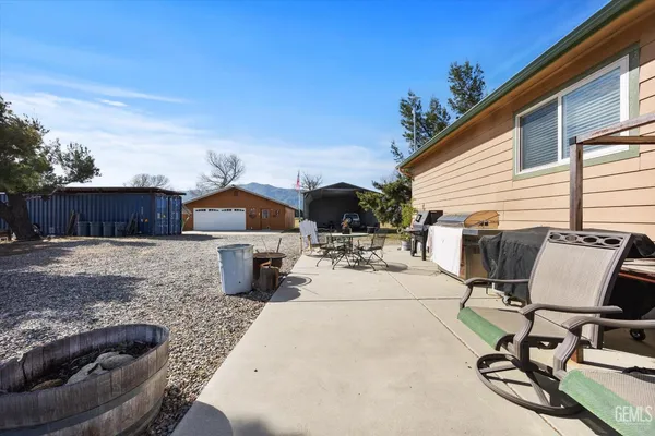 a view of a backyard with couches chair and wooden floor