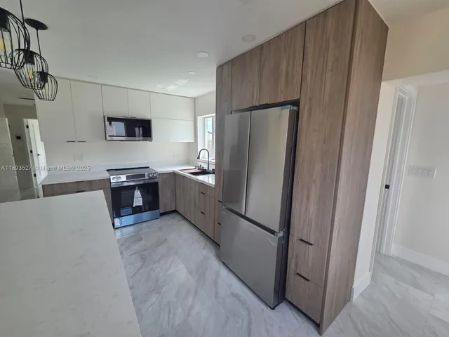 a kitchen with stainless steel appliances a refrigerator and a sink