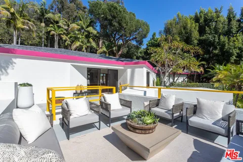 a roof deck with couches and potted plants