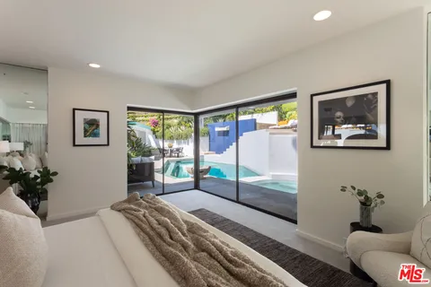 a bedroom with a large bed and a potted plant