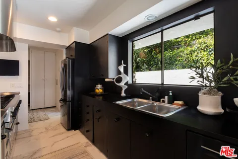 a kitchen with a sink refrigerator and microwave