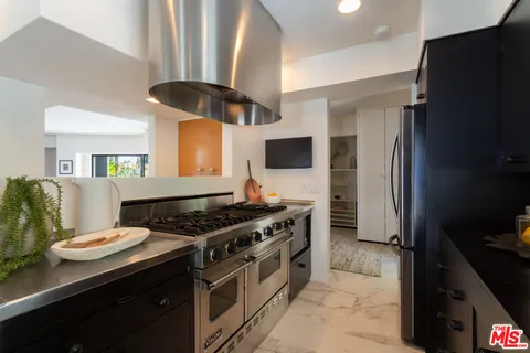 a kitchen with stainless steel appliances a stove a refrigerator and a stove