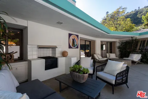 a living room with furniture potted plant and kitchen view