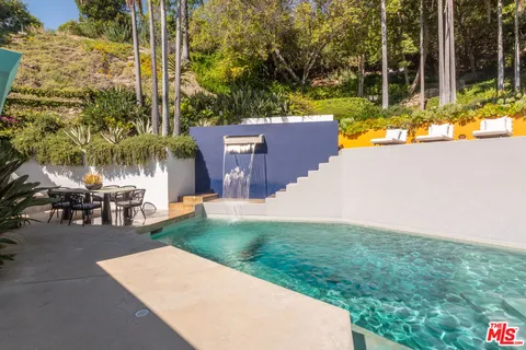 swimming pool view with a seating space and a garden