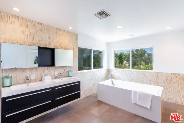 a bathroom with a large tub sink and window