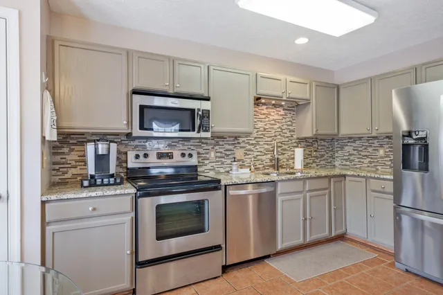 a kitchen with cabinets stainless steel appliances and sink