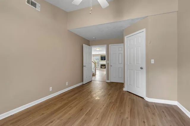 a view of a kitchen with a fridge and wooden floor