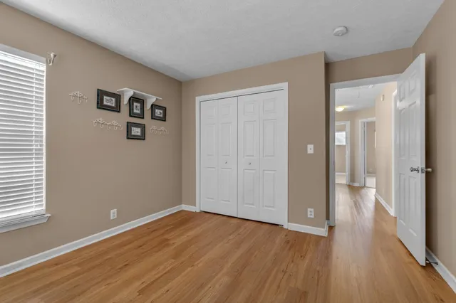 a view of a big room with wooden floor and windows