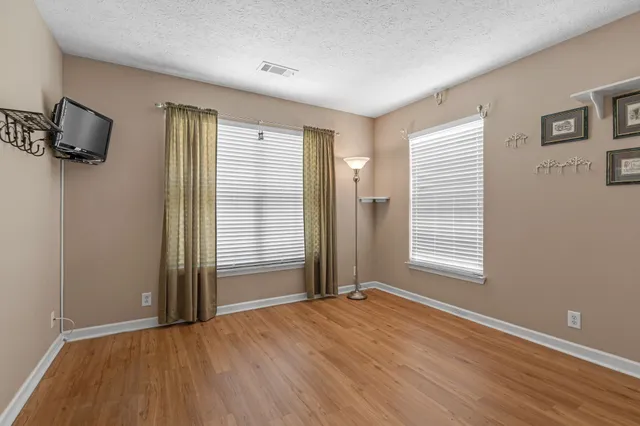 a view of an empty room with a window and a flat screen tv