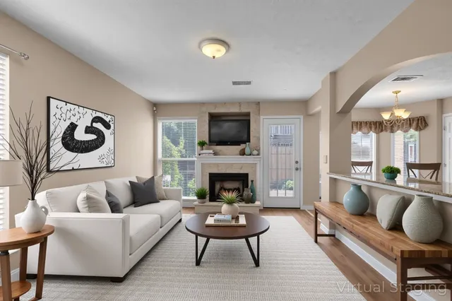 a living room with furniture a rug a fireplace and a flat screen tv