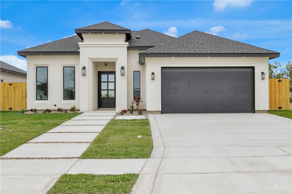 Prairie-style house with a shingled roof, a gate, stucco siding, and concrete driveway