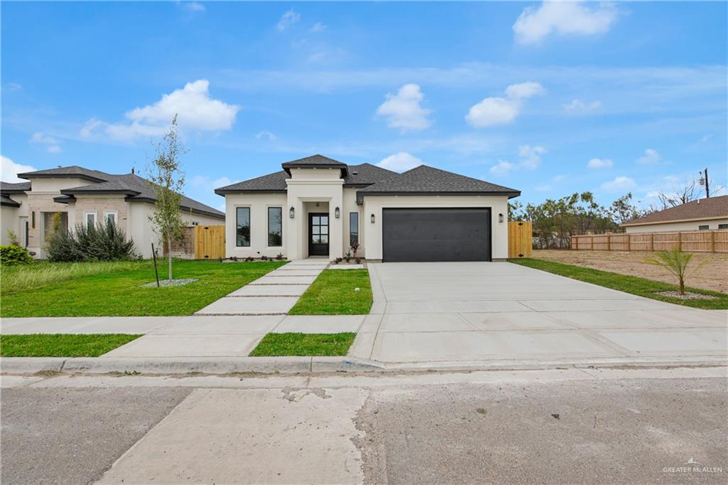 608 Spring Drive Alton, TX 78573 - Photo 3 of 32 Prairie-style home with driveway, a garage, stucco siding, and a shingled roof