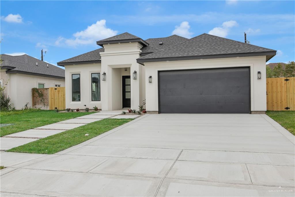 608 Spring Drive Alton, TX 78573 - Photo 5 of 32 Prairie-style house featuring roof with shingles, a gate, concrete driveway, a garage, and stucco siding