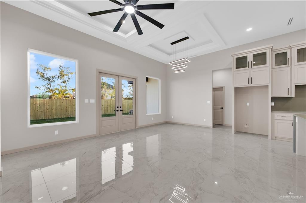 608 Spring Drive Alton, TX 78573 - Photo 8 of 32 Spare room with french doors, coffered ceiling, light marble finish flooring, a high ceiling, and ceiling fan
