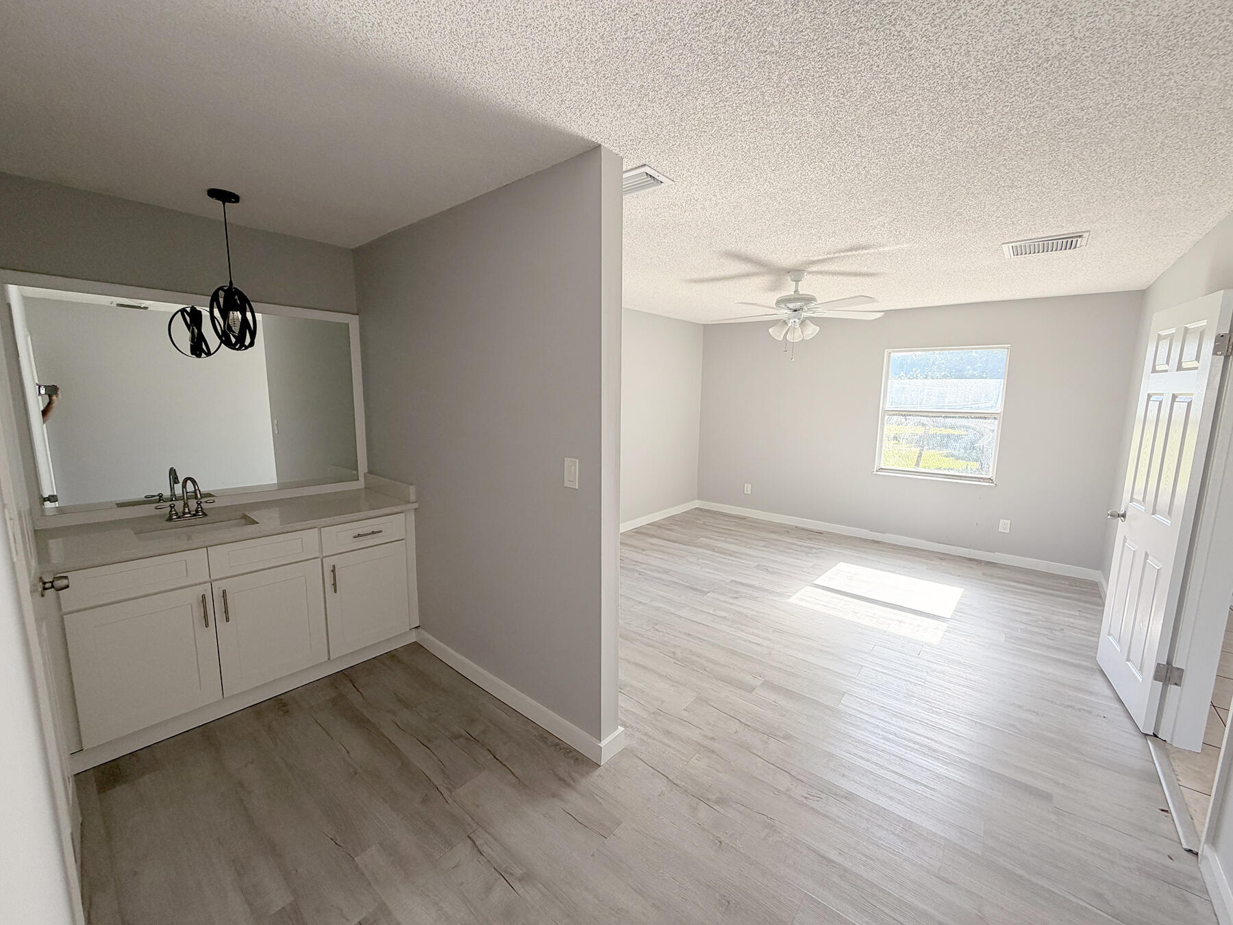 1902 Southeast Gena Road Port St. Lucie, FL 34952 - Photo 4 of 9 a view of a kitchen with a sink dishwasher and wooden floor
