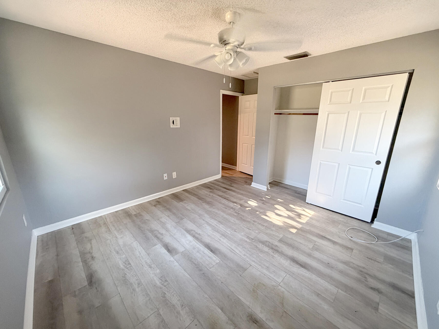 1902 Southeast Gena Road Port St. Lucie, FL 34952 - Photo 6 of 9 wooden floor in an empty room with a window