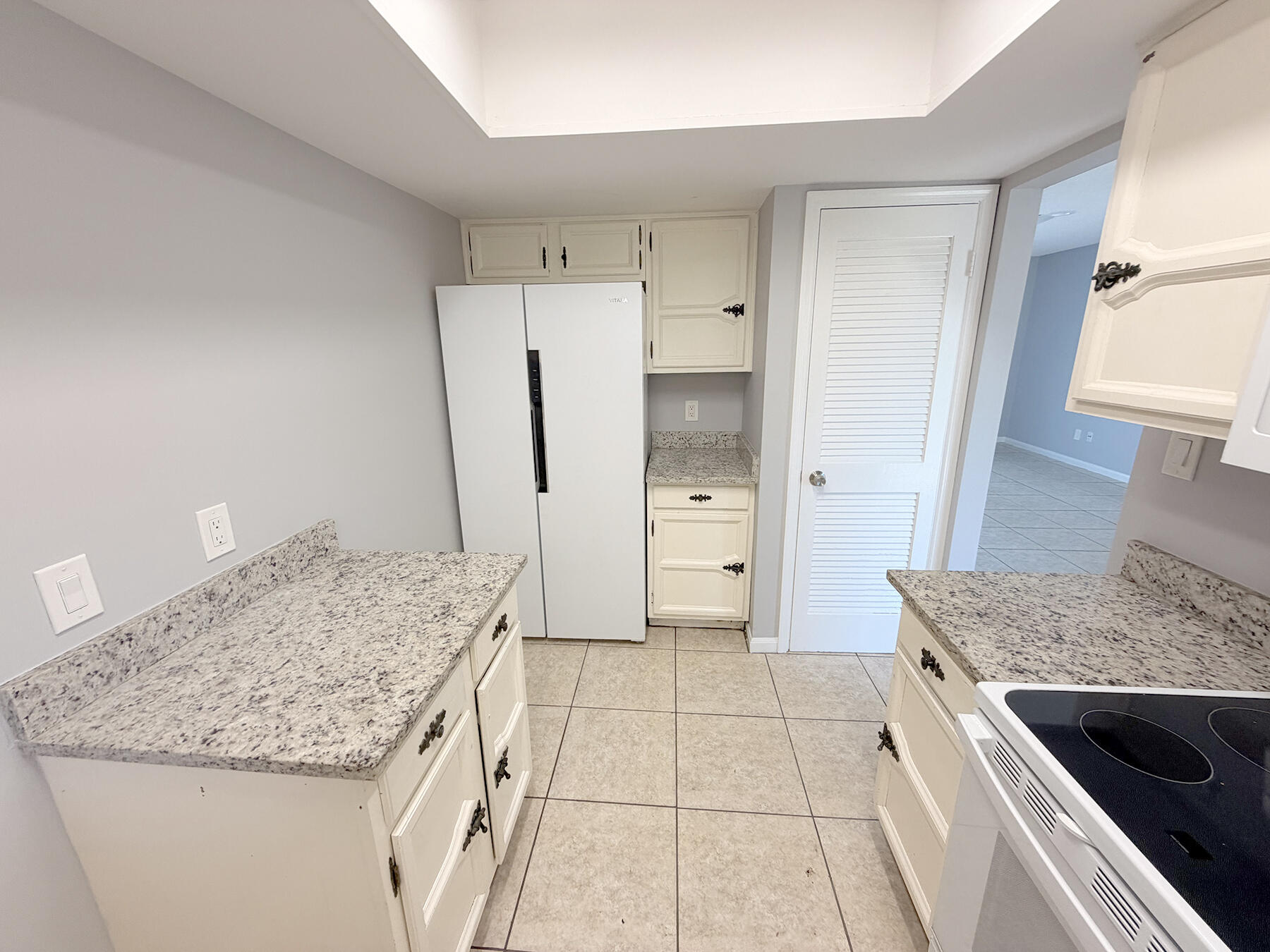 1902 Southeast Gena Road Port St. Lucie, FL 34952 - Photo 7 of 9 a kitchen with granite countertop a sink stove and refrigerator