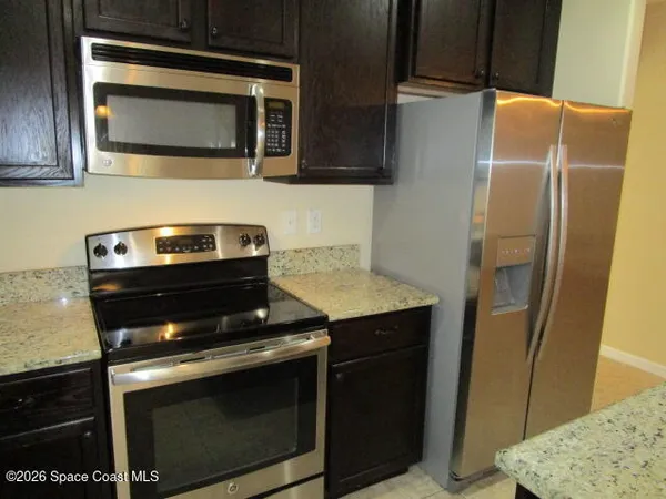 a kitchen with stainless steel appliances wooden cabinets and a stove top oven